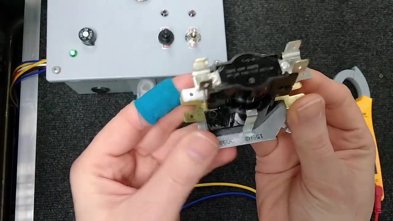 Testing a heat sequencer with a multimeter for continuity across terminals